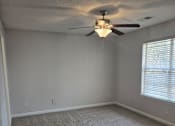 Thumbnail 38 of 49 - A room with a ceiling fan and carpeted floor.