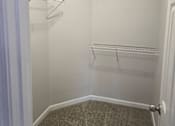Thumbnail 39 of 49 - A white closet with a carpeted floor and a white door.