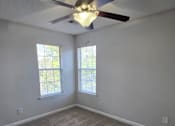 Thumbnail 41 of 49 - A room with a ceiling fan and two windows.