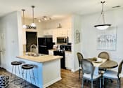 Thumbnail 21 of 33 - A kitchen with a bar and a dining table.