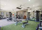 Thumbnail 47 of 69 - A well-equipped gym with a variety of exercise machines and a green artificial turf area at Highline Urban Lofts Apartments, Cypress, Texas