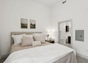Thumbnail 7 of 48 - A bedroom with a large bed and two pictures on the wall at Everra Midtown Park Apartments, Dallas, TX, 75231