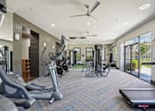 Thumbnail 50 of 69 - A spacious gym with a variety of equipment including treadmills, elliptical machines, and weight machines at Highline Urban Lofts Apartments, Cypress, Texas