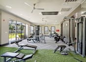 Thumbnail 49 of 69 - A gym with a variety of equipment including weights, a bench press, and a treadmill at Highline Urban Lofts Apartments, Cypress