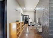 Thumbnail 54 of 69 - A long hallway with a brick wall and a sink at Highline Urban Lofts Apartments, Cypress, TX, 77429