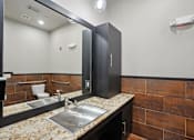 Thumbnail 55 of 69 - A bathroom with a sink, mirror, and toiletries at Highline Urban Lofts Apartments, Cypress, TX