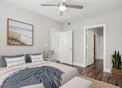 Thumbnail 8 of 69 - A bedroom with a bed, a ceiling fan, and a painting on the wall at Highline Urban Lofts Apartments, Cypress