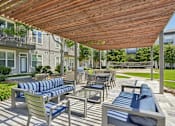 Thumbnail 38 of 69 - A wooden patio with blue cushions and chairs at Highline Urban Lofts Apartments, Texas