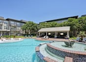Thumbnail 58 of 69 - A swimming pool with a fountain in the middle of it at Highline Urban Lofts Apartments, Cypress, TX