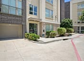Thumbnail 41 of 48 - A building with a garage door and a red line on the sidewalk at Everra Midtown Park Apartments, Dallas, Texas
