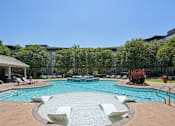 Thumbnail 56 of 69 - A large swimming pool surrounded by lounge chairs and trees at Highline Urban Lofts Apartments, Texas