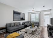Thumbnail 11 of 69 - A living room with a grey couch, a coffee table, and a painting on the wall at Highline Urban Lofts Apartments, Texas
