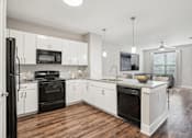 Thumbnail 13 of 69 - A modern kitchen with black appliances and white cabinets at Highline Urban Lofts Apartments, Cypress, TX, 77429