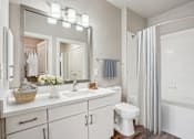 Thumbnail 10 of 69 - A white bathroom with a white toilet, sink, and bathtub at Highline Urban Lofts Apartments, Cypress, TX