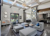Thumbnail 29 of 69 - A modern living room with grey couches and a chandelier at Highline Urban Lofts Apartments, Cypress 77429