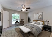 Thumbnail 5 of 32 - A bedroom with a bed, chair, and ceiling fan.