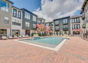 Thumbnail 41 of 53 - Courtyard pool with sundeck and lounge chairs at The Barton Apartments, Dallas, Texas