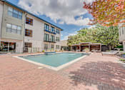 Thumbnail 30 of 53 - Swimming pool with cabanas and paver deck at The Barton Apartments, Dallas, TX 75206