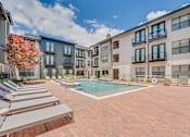 Thumbnail 38 of 53 - Courtyard pool with spa and lounge seating at The Barton Apartments, Dallas, TX