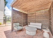 Thumbnail 42 of 53 - Covered outdoor patio with wood privacy screens at The Barton Apartments, Dallas, Texas