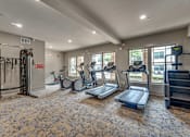 Thumbnail 51 of 69 - A gym with treadmills, elliptical machines, and other exercise equipment.