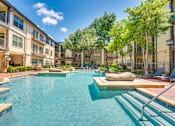 Thumbnail 35 of 69 - A swimming pool in a residential area surrounded by trees and buildings.