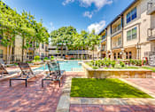 Thumbnail 30 of 69 - A pool surrounded by lawn chairs and trees.