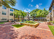 Thumbnail 40 of 69 - A sunny day at a brick courtyard with a pool and trees.