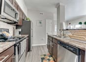 Thumbnail 12 of 81 - A kitchen with a black fridge and a black stove top oven. at The Brazos, Dallas, TX
