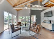 Thumbnail 29 of 42 - A living room with brown leather chairs and a glass table at Copper Hill Apartments, Bedford, TX
