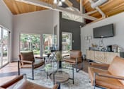 Thumbnail 28 of 42 - A modern living room with brown leather chairs and a glass coffee table at Copper Hill Apartments, Bedford, TX, 76021