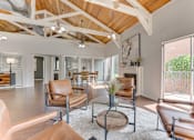 Thumbnail 26 of 42 - A living room with brown leather chairs and a wooden coffee table at Copper Hill Apartments, Bedford, TX, 76021