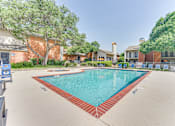 Thumbnail 15 of 42 - A large swimming pool surrounded by a red brick border at Copper Hill Apartments, Texas, 76021