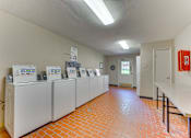 Thumbnail 22 of 42 - A room with a row of refrigerators and a fire extinguisher at Copper Hill Apartments, Bedford