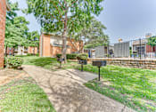 Thumbnail 37 of 42 - A tree stands in a grassy area in front of a brick building at Copper Hill Apartments, Bedford, TX, 76021