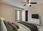 Thumbnail 6 of 42 - A living room with a grey sofa and a ceiling fan at Copper Hill Apartments, Bedford, TX