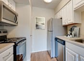 Thumbnail 4 of 42 - A kitchen with a refrigerator, stove, and dishwasher at Copper Hill Apartments, Bedford