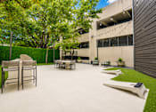 Thumbnail 31 of 53 - Outdoor entertaining patio with grilling station and string lights at The Barton Apartments, Dallas, Texas