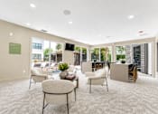 Thumbnail 12 of 53 - Community clubroom with patio access and seating at The Barton Apartments, Dallas, TX