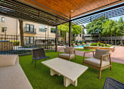 Thumbnail 44 of 69 - A patio with a table and chairs under a roof.
