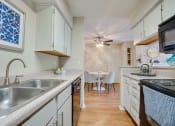 Thumbnail 6 of 57 - a kitchen with a sink and a stove and a dining room at Indian Creek Apartments, Carrollton, TX
