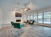 Thumbnail 17 of 57 - a living room with a large window and a ceiling fan at Indian Creek Apartments, Carrollton, TX