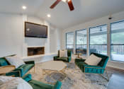 Thumbnail 15 of 57 - a living room with green chairs and a fireplace at Indian Creek Apartments, Carrollton, Texas