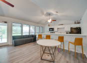 Thumbnail 20 of 57 - a living room with a round table and a kitchen with a couch at Indian Creek Apartments, Carrollton