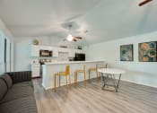 Thumbnail 19 of 57 - a living room with a kitchen and a dining table at Indian Creek Apartments, Carrollton, 75007