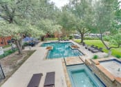 Thumbnail 30 of 57 - a backyard with a swimming pool and trees at Indian Creek Apartments, Carrollton, TX