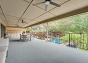 Thumbnail 25 of 57 - a large covered porch with a pool and a table and chairs at Indian Creek Apartments, Carrollton, 75007