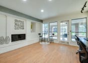 Thumbnail 16 of 57 - a living room with a fireplace and a wood floor    and a balcony at Indian Creek Apartments, Carrollton, 75007