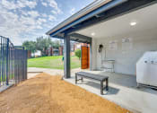 Thumbnail 38 of 57 - a covered patio with a hot tub and a wooden bench at Indian Creek Apartments, Texas