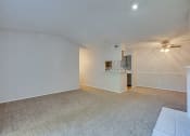 Thumbnail 52 of 57 - an empty living room with a ceiling fan and a kitchen at Indian Creek Apartments, Texas